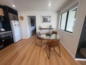 a kitchen with a glass table and chairs in a room at Derwent Waters Hideway in Austins Ferry