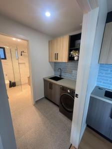 a kitchen with a sink and a washing machine at Derwent Waters Hideway in Austins Ferry