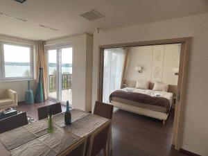 a bedroom with a bed and a dining room with a table at T8 Sunset Tihany in Tihany