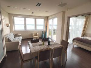 a living room with a dining table and a room with a bed at T8 Sunset Tihany in Tihany +32 photos