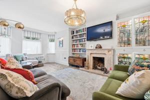 a living room with a tv and a fireplace at Hillsley House in Wirksworth