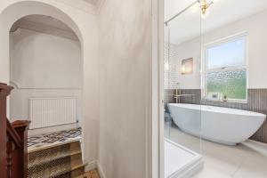 a white bathroom with a tub and a window at Hillsley House in Wirksworth +29 photos