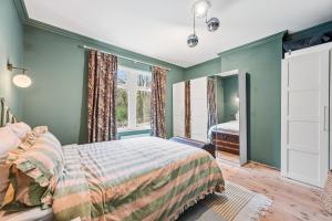 a bedroom with green walls and a bed at Hillsley House in Wirksworth