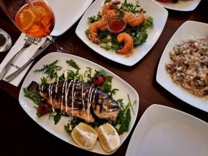 a table with plates of food with fish and rice at Hotel - PLATIA in Günzburg