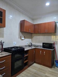 a kitchen with wooden cabinets and a black stove at Luxury Home Away in Aja