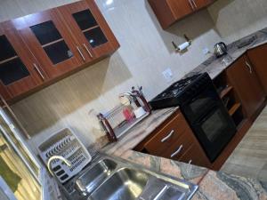 a kitchen with a sink and a microwave at Luxury Home Away in Aja +2 photos