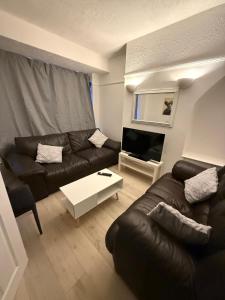 a living room with a couch and a table at Short Stay & Long Stay home in Ellesmere Port in Little Sutton