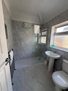a bathroom with a shower and a toilet and a sink at Short Stay & Long Stay home in Ellesmere Port in Little Sutton