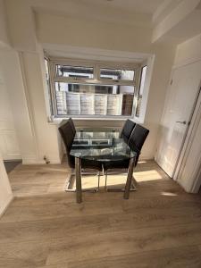 a glass table and chairs in a room with a window at Short Stay & Long Stay home in Ellesmere Port in Little Sutton +9 photos
