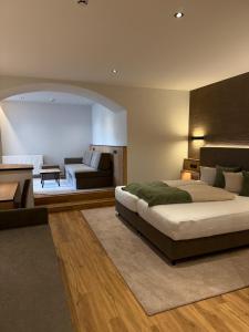 a bedroom with a large bed and a living room at Hotel Gasthof Neuner in Imst
