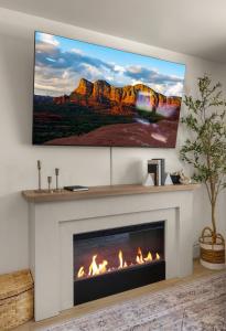 a living room with a fireplace with a tv above it at Page House in Gilbert