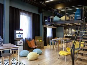 a room with tables and chairs and a bunk bed at Novotel Lyon Gerland in Lyon
