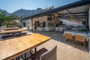 a patio with wooden tables and chairs and tablesearcher at The Turunç INN Otel in Turunç