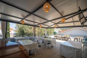 a restaurant with white tables and chairs and windows at The Turunç INN Otel in Turunç