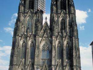 a large cathedral with a tall building in the background at Ibis Hotel Köln Am Dom in Cologne