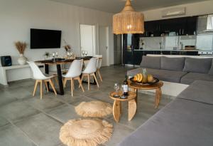 a living room with a couch and a table and chairs at Erimo Vip in Vourvoúlos