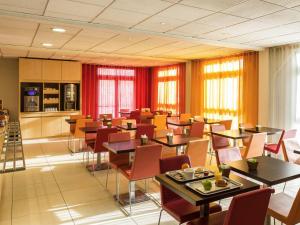 a restaurant with tables and chairs in a room at ibis Aulnay Paris Nord Expo in Aulnay-sous-Bois