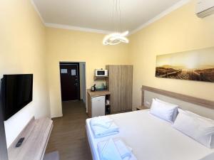 a bedroom with a white bed and a tv at Stamopolu Lux ground floor in Primorsko