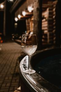 a glass of wine sitting next to a bath tub at Piparmētras in Mērsrags +19 photos