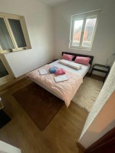 a small bedroom with a bed with pink pillows at Jagoda IN in Otroci