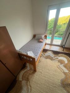 a small bed in a room with a large window at Jagoda IN in Otroci +20 photos