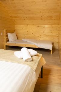 two beds in a room with wooden walls at Meștera 9 in Stînceni