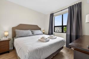 a bedroom with a bed with towels on it at Luxury Playa Del Sol Condo 435 w Pool, Hot Tub & Beach Nearby in Kelowna +20 photos