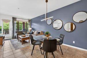 a living room with a table and chairs and mirrors at Luxury Playa Del Sol Condo 435 w Pool, Hot Tub & Beach Nearby in Kelowna