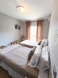 a bedroom with two beds and a tv on the wall at Residencial Do Rita em Rio Caldo in Geres