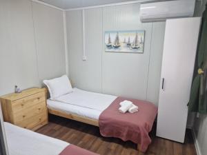 a small bedroom with two beds and a dresser at Bungalows Rea in Burgas