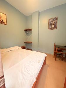 ein Schlafzimmer mit einem weißen Bett und einem Tisch in der Unterkunft Hotel Riomar in Iquitos + 4 Fotos