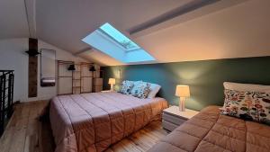 a bedroom with two beds and a skylight at Villa Annabelle "Azur" appartement de charme entre océan et forêt à Messanges in Messanges