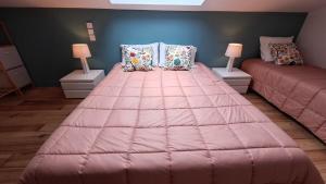 a large pink bed in a room with two lamps at Villa Annabelle "Azur" appartement de charme entre océan et forêt à Messanges in Messanges