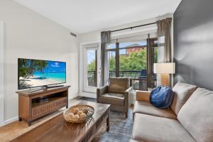a living room with a couch and a tv at Luxury Playa Del Sol Condo 435 w Pool, Hot Tub & Beach Nearby in Kelowna