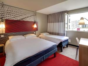 a hotel room with two beds and a window at ibis Orleans Centre Gare in Orléans +78 photos