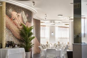 a dining room with white tables and white chairs at Hotel Kore in Villaggio Mosè