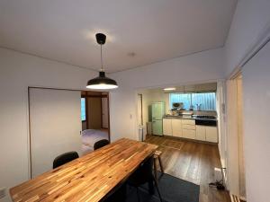 a kitchen and dining room with a wooden table at Shirako House in Shirako
