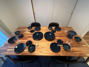 a wooden table with plates and wine glasses on it at Shirako House in Shirako