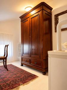 a large wooden cabinet in a room with a rug at il canto del lago in Iseo