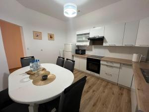 a white kitchen with a white table and chairs at Ebram Apartments Görlitz in Görlitz