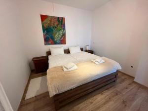 a bedroom with two beds and a painting on the wall at Ebram Apartments Görlitz in Görlitz