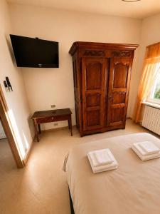 a bedroom with a bed and a tv on the wall at il canto del lago in Iseo