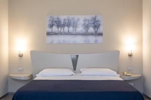 a bedroom with a bed and a painting on the wall at Hotel Kore in Villaggio Mosè +26 photos