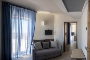 a living room with a couch and a large window at Hotel Kore in Villaggio Mosè