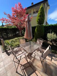 a table and two chairs and an umbrella on a patio at Casa Aurora Gardalake in Cavalcaselle