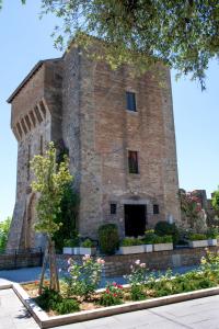 a large brick building with flowers in front of it at Torre Caetani- Night in a medieval tower in Todi
