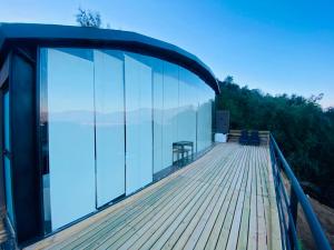 a house with glass walls and a wooden deck at Apalta Vista Wine Lodge in Estación Santa Cruz
