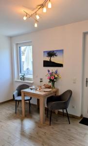 a dining room with a table and two chairs at Ferienwohnung Am Kleinen Haff in Garz
