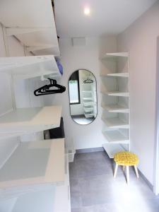 a room with white shelves and a round mirror at Spacious house with garden in Soustons
