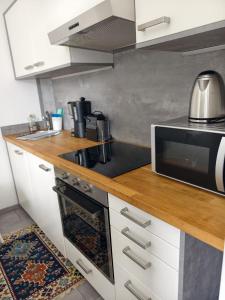 a kitchen with a stove and a microwave at Apartment Central Mutters Innsbruck in Innsbruck